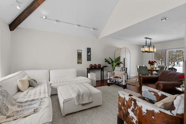 living area with vaulted ceiling with beams, a chandelier, and rail lighting