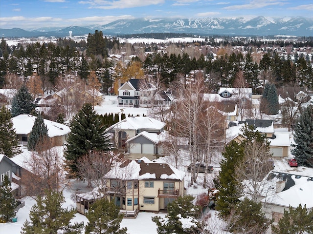 snowy aerial view featuring a residential view and a mountain view