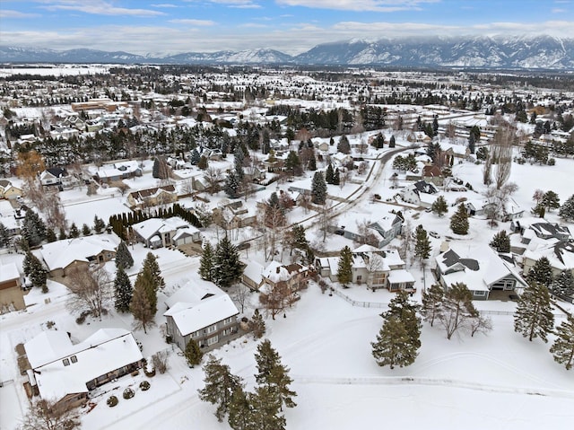 snowy aerial view featuring a residential view and a mountain view