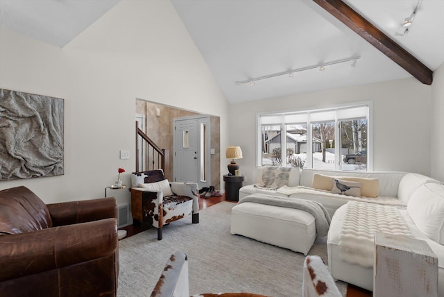 living area with stairway, wood finished floors, beamed ceiling, rail lighting, and high vaulted ceiling