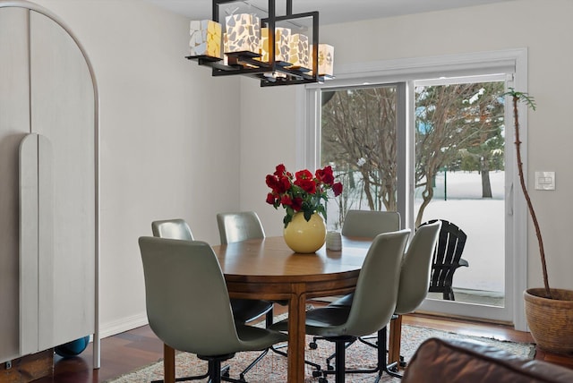 dining room with a chandelier, wood finished floors, and baseboards