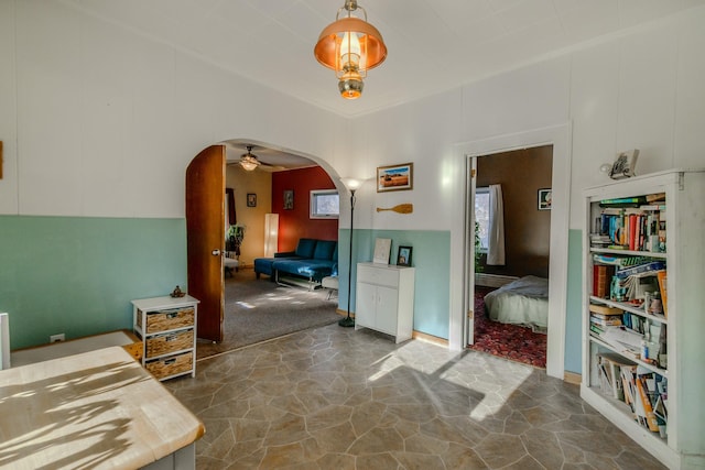 hallway with arched walkways and stone finish flooring