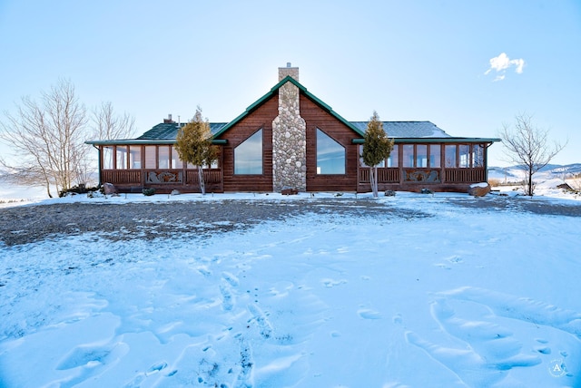 exterior space featuring a chimney and a sunroom