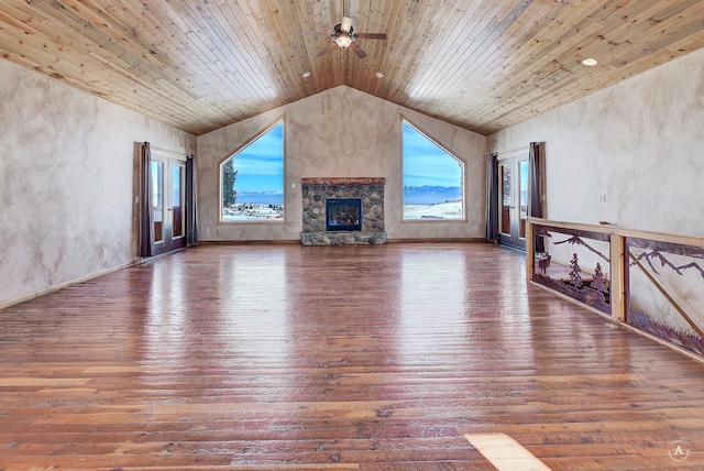 3 Paradise Ridge Rd, Clancy, MT 59634 - unfurnished living room with hardwood / wood-style flooring, vaulted ceiling, wood ceiling, a stone fireplace, and ceiling fan