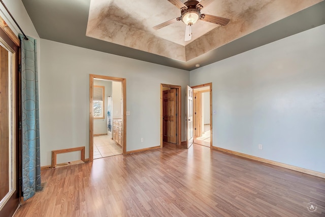3 Paradise Ridge Rd, Clancy, MT 59634 - unfurnished bedroom with baseboards, a tray ceiling, light wood finished floors, ensuite bathroom, and a spacious closet