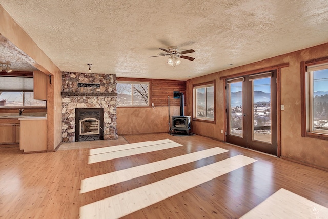 3 Paradise Ridge Rd, Clancy, MT 59634 - unfurnished living room with a textured ceiling, light wood-style flooring, ceiling fan, a wood stove, and a sink