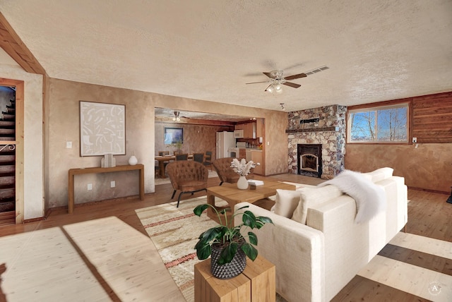 3 Paradise Ridge Rd, Clancy, MT 59634 - living area featuring a textured ceiling, ceiling fan, wood finished floors, and a stone fireplace
