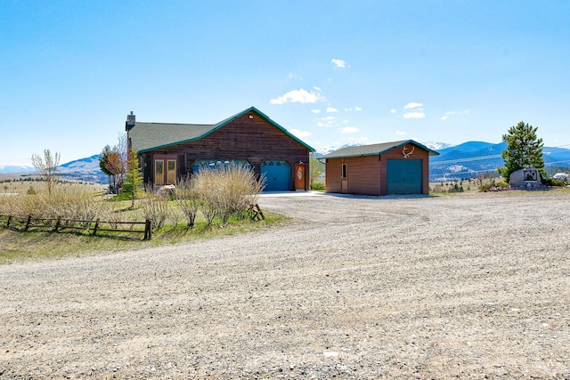 3 Paradise Ridge Rd, Clancy, MT 59634 - view of front of house with a garage, a mountain view, an outbuilding, and a chimney