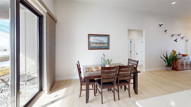 dining space featuring light wood-style flooring and baseboards