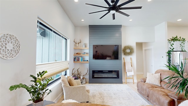 living area featuring a healthy amount of sunlight, a large fireplace, and recessed lighting