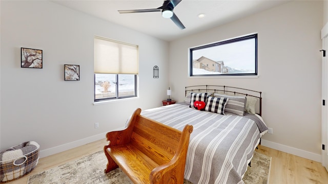 bedroom with wood finished floors, a ceiling fan, and baseboards