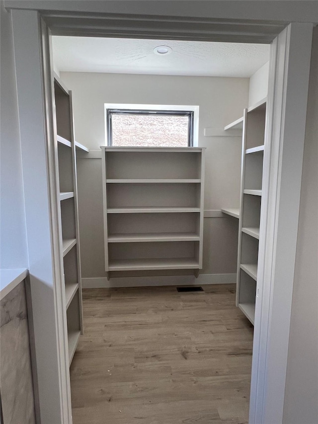 walk in closet featuring visible vents and wood finished floors