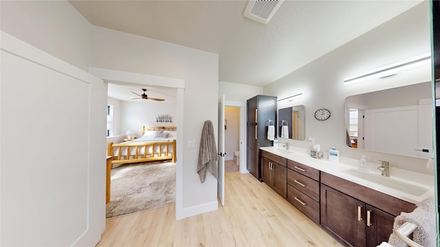 bathroom with toilet, visible vents, a sink, and wood finished floors