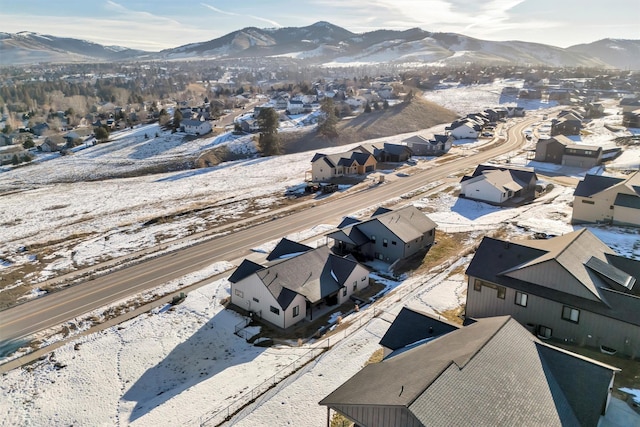 snowy aerial view with a residential view and a mountain view