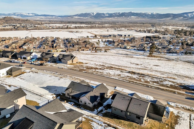 snowy aerial view with a residential view and a mountain view