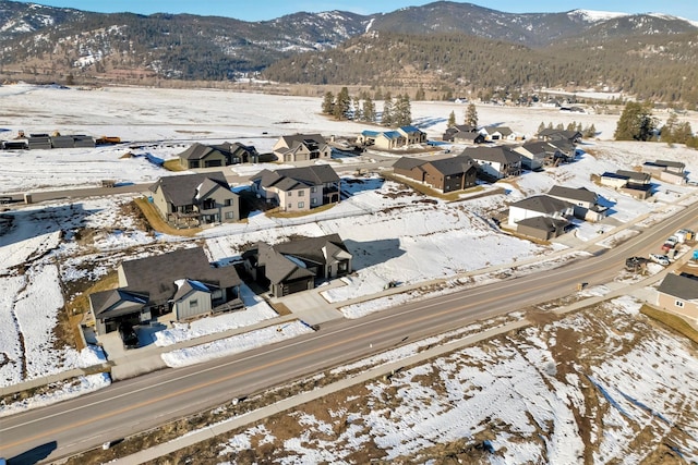 snowy aerial view with a residential view and a mountain view