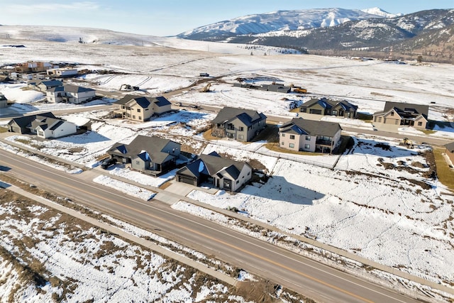 snowy aerial view featuring a residential view and a mountain view