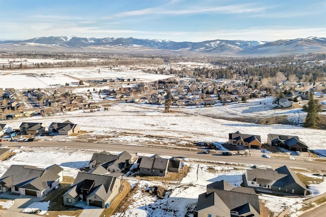 snowy aerial view with a residential view and a mountain view