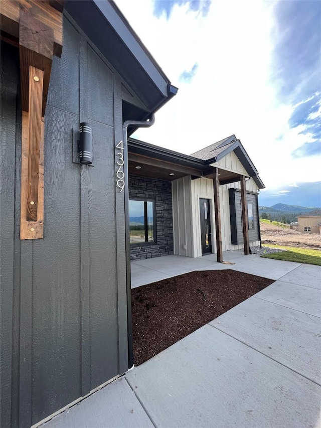 exterior space with stone siding, board and batten siding, and a patio area