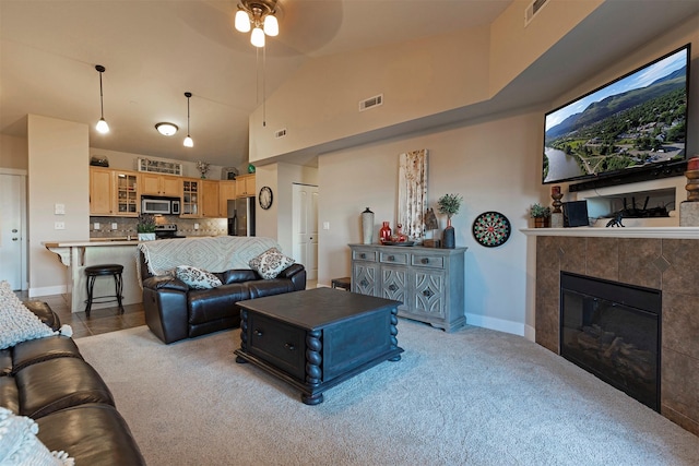 2025 Mullan Rd Unit 409, Missoula, MT 59808 - living area with a ceiling fan, a tile fireplace, high vaulted ceiling, and light colored carpet