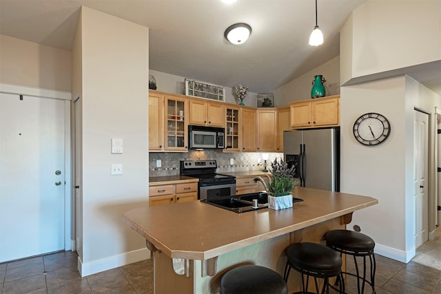 2025 Mullan Rd Unit 409, Missoula, MT 59808 - kitchen with stainless steel appliances, backsplash, light brown cabinets, a breakfast bar, and dark tile patterned flooring