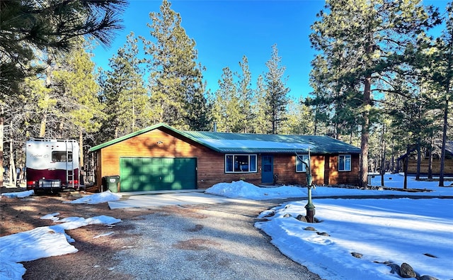 view of front of property with a garage, driveway, and metal roof