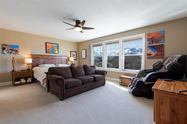 bedroom featuring light carpet, a ceiling fan, and baseboards