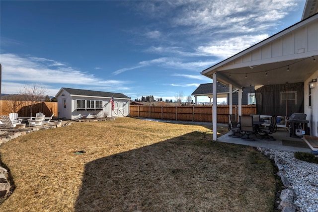 view of yard featuring a fenced backyard, a patio, a fire pit, and an outdoor structure