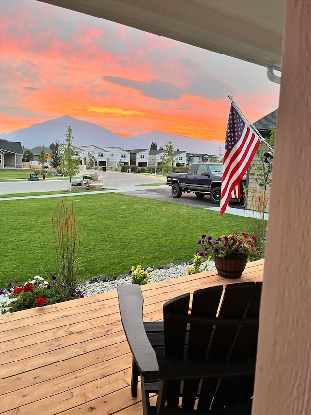 wooden deck with a residential view and a lawn