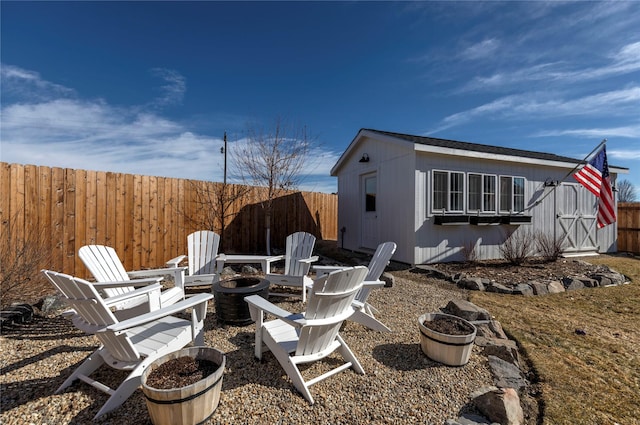 view of yard featuring an outdoor fire pit, fence, and an outbuilding