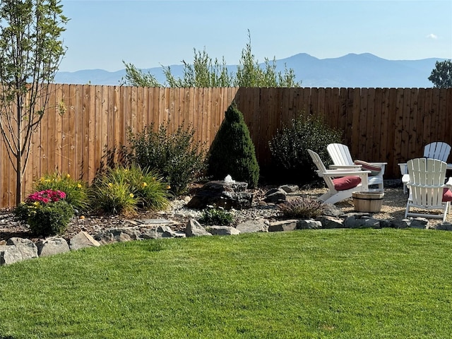 view of yard featuring a fenced backyard and a mountain view