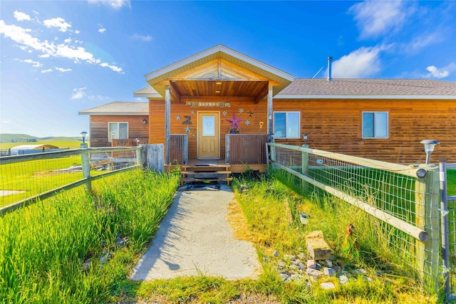 view of front of property with roof with shingles and fence