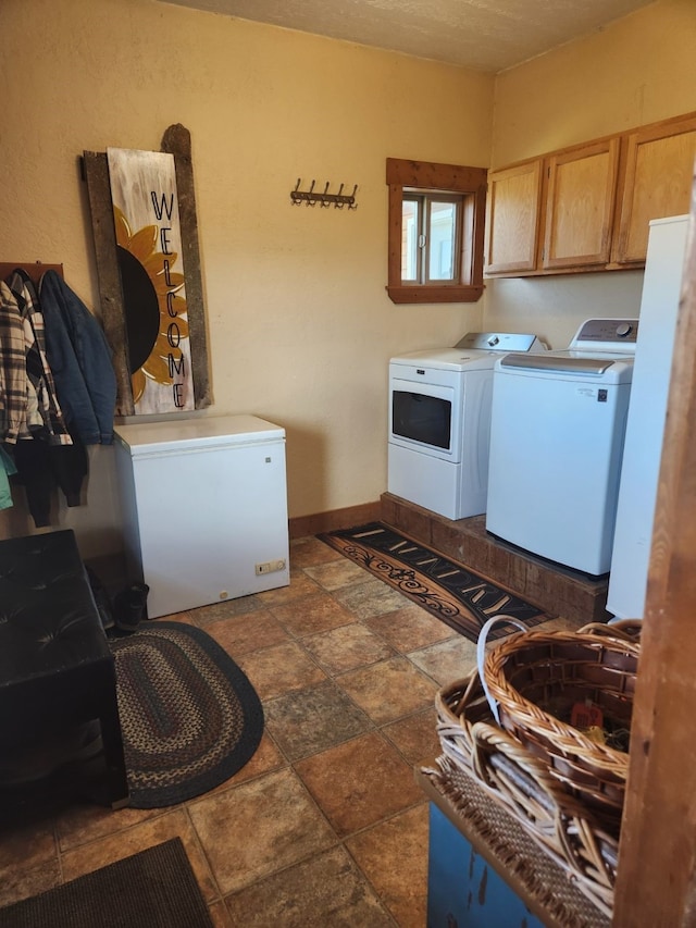 laundry area featuring cabinet space, washing machine and dryer, and baseboards