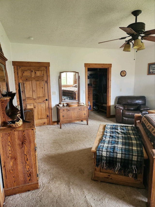 living room featuring carpet, a ceiling fan, and a textured ceiling