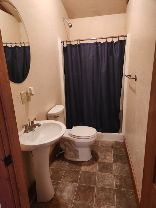 bathroom featuring baseboards, toilet, and a shower with curtain