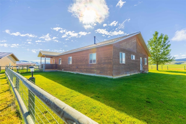 exterior space featuring a lawn and fence