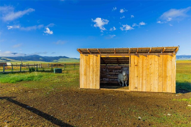 back of house featuring a carport, an outbuilding, metal roof, and a mountain view