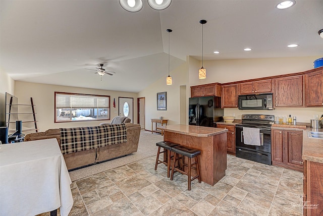 kitchen with lofted ceiling, a breakfast bar area, open floor plan, a center island, and black appliances