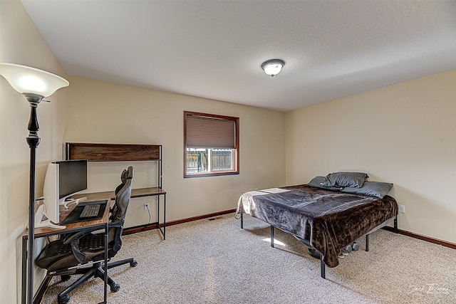 carpeted bedroom with a textured ceiling and baseboards