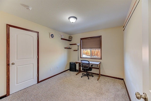 unfurnished office with carpet flooring, a textured ceiling, and baseboards