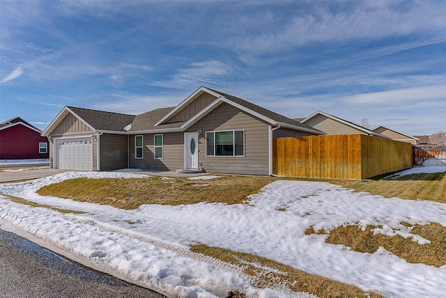 view of front of house with board and batten siding, fence, and a garage