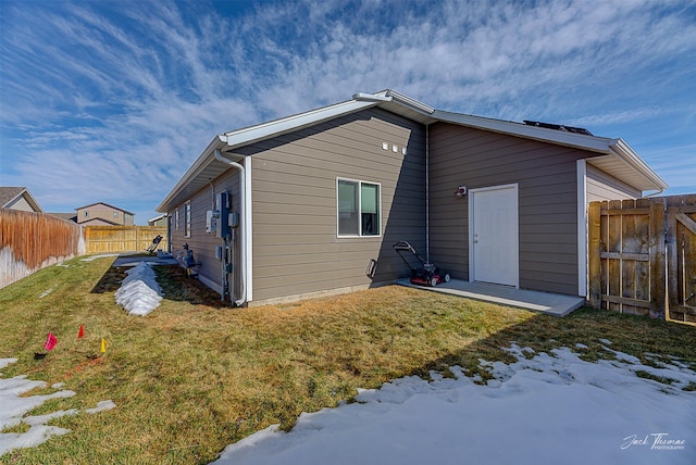 back of property featuring a yard and fence