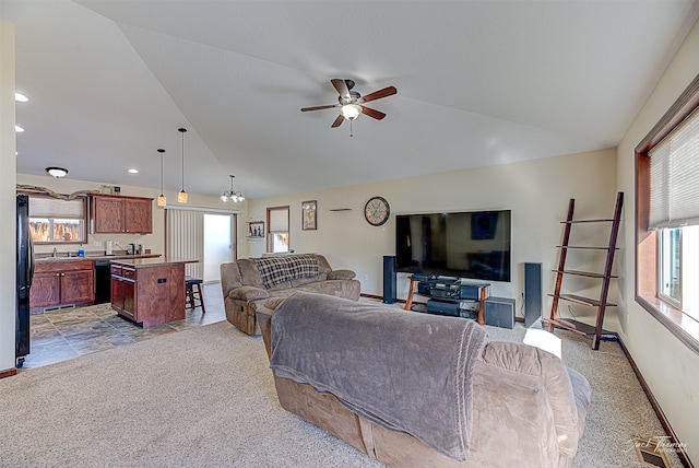 living room with lofted ceiling, ceiling fan with notable chandelier, visible vents, and baseboards