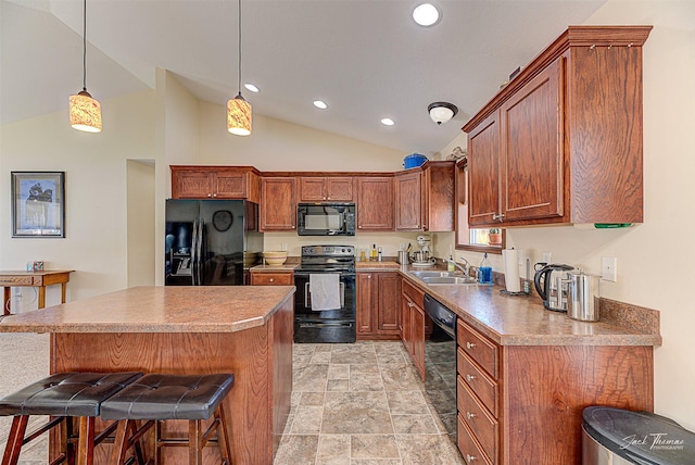 kitchen featuring decorative light fixtures, black appliances, a kitchen bar, a sink, and recessed lighting