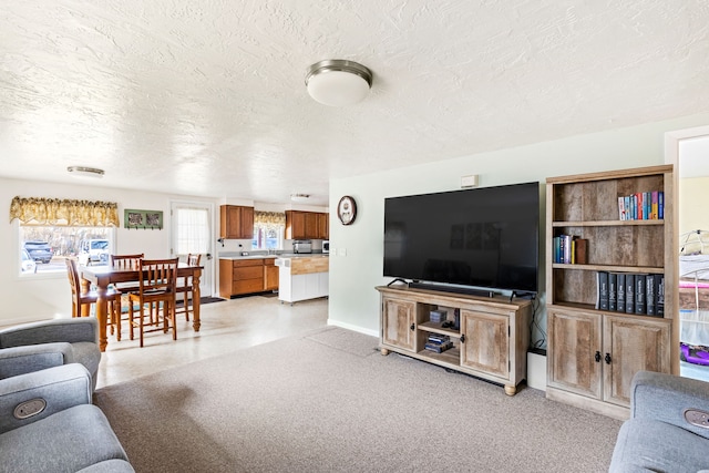 living room featuring light carpet, a textured ceiling, and baseboards