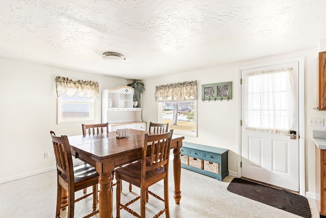 dining room featuring baseboards and a textured ceiling