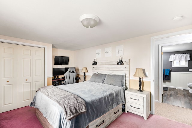 carpeted bedroom featuring a closet and wainscoting