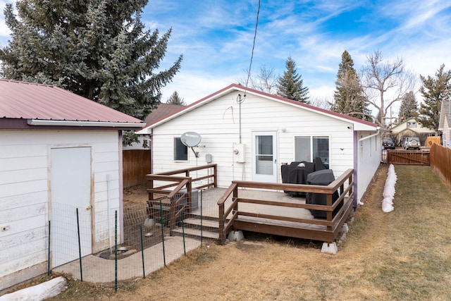 back of house with a fenced backyard, metal roof, and a wooden deck