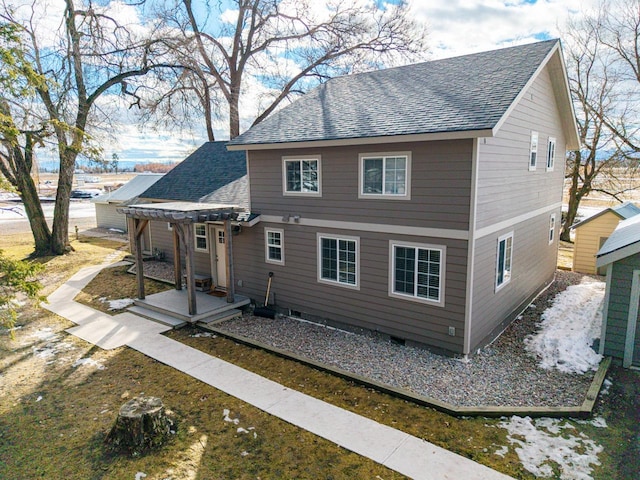 rear view of house featuring roof with shingles