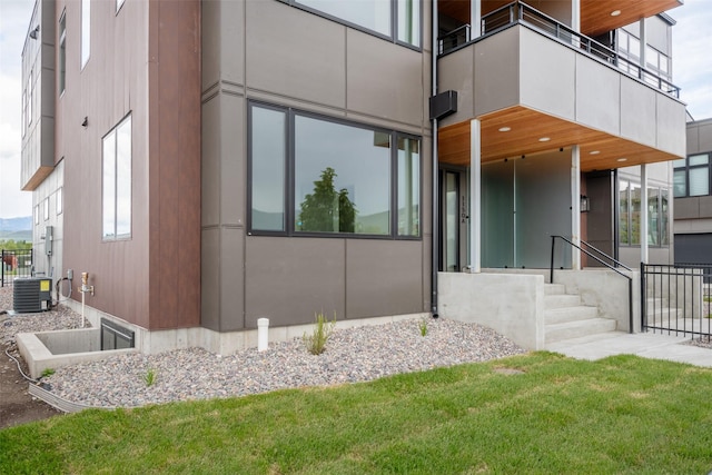 exterior space with a balcony, central AC, and a yard